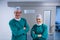 Portrait of happy surgeons standing in corridor