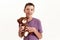 Portrait of happy teenaged disabled boy with cerebral palsy smiling at camera and holding his teddy bear toy, posing