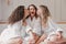 Portrait of happy three girls bridesmaids 20s in bathrobe having