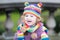 Portrait of a happy toddler girl in colorful knitted hat