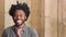 Portrait of a happy trendy man with a wooden background and copy space. Confident African American student or young