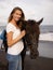 Portrait of happy woman and brown horse. Caucasian woman hugging horse. Romantic concept. Love to animals. Nature concept. Bali