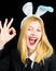 Portrait of a happy woman in bunny ears winking. Closeup of winking bunny girl face. Pretty bunny girl winking and show