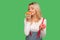 Portrait of happy woman enjoying smell of delicious grapefruit while holding sweet donut in other hand