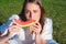 Portrait of happy woman enjoying summer and eat watermelon in park. Youth girl about biting wedge of juicy watermelon