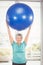 Portrait of happy woman holding blue exercise ball
