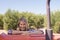 Portrait of happy woman leaning on tractor in olive farm