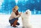 Portrait of happy woman owner having fun with white Samoyed dog