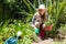 Portrait of happy woman planting sapling in garden