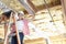 Portrait of a happy woman standing on ladder working on unfinished ceiling