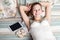 Portrait of happy woman with sweets and tablet lying down on her bed.