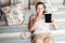 Portrait of happy woman with sweets and tablet lying down on her bed.