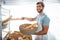 Portrait of happy worker holding basket of bread