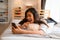 Portrait of happy young Asian girl in casual clothing lying down on bed while making a video call with smartphone in