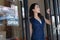 Portrait of a happy young Asian owner small business standing at restaurant, cafe entrance door. Cheerful owner of cafe showing