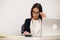 Portrait Of Happy Young Businesswoman Sitting At Desk Calculating Finance