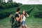 Portrait of happy young couple with backpacks on the field in spring. Man and woman walking in currant plantations