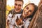 Portrait of happy young couple with dogs outdoors in autumn park