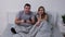 Portrait of happy young couple posing while lying in bedroom on bed. Man with passion plays a game with a wireless