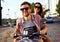 Portrait of happy young couple on scooter enjoying road trip