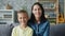 Portrait of happy young family mother and son smiling sitting together indoors