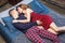 Portrait of happy young family sleeping in the bedroom, in sleepwear lying on bed with blue knitting plaid enjoying each other.