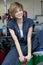 Portrait of a happy young female mechanic sitting on oil drum in car workshop