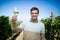 Portrait of happy young man holding wineglass at vineyard