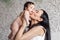 Portrait of happy young mother kissing tenderly little daughter in bedroom. Carefully hold naked baby in hands overhead