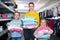 Portrait of happy young mother with two little daughters holding new towels in shop