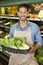 Portrait of a happy young salesperson with bok choy in market