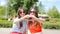 Portrait of happy young urban girls in european city. Caucasian tourists making hearts by their hands in the