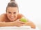 Portrait of happy young woman with apple laying on massage table