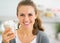 Portrait of happy young woman drinking smoothie in kitchen