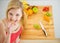 Portrait of happy young woman having a bite while cutting salad