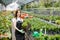 Portrait of a hardworking european farmer woman in a greenhouse holding box with flower pots. Home gardening, love of plants and