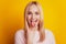 Portrait of harsh hipster girl protrude tongue hands show horns gesture on yellow background