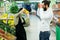 Portrait of a healthy couple looking at fruits and vegetables in the supermarket while shopping. Cheerful couple