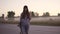 Portrait of a hipster close-up. The red-haired girl walks along a deserted highway with a skateboard in her hands