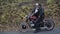 Portrait of hipster couple stands at motorbike and talking in park