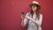 Portrait of hipster tourist woman in front of red wall using smart phone