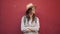 Portrait of hipster tourist woman in front of red wall. Woman wearing stripped blouse and straw hat