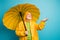 Portrait of his he dissatisfied grey-haired man wearing yellow overcoat holding rainy drop on palm waiting expecting