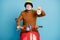 Portrait of his he nice attractive cheerful cheery confident bearded grey-haired man riding moped holding in hand