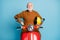 Portrait of his he nice attractive cheerful cheery content bearded grey-haired man riding moped having fun rental