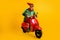 Portrait of his he nice attractive cheerful cheery glad ecstatic funny guy elf riding red moped having fun festal look