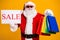 Portrait of his he nice attractive cheerful confident fat Santa holding in hands things buyings board sale advert ad