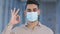 Portrait hispanic young happy man responsible patient sick human guy wears medical protective mask on male face looking