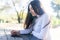 Portrait of a hispanic young woman using mobile phone in park on sunny day smiling - very happy woman on cellphone