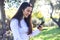 Portrait of a hispanic young woman using mobile phone in park on sunny day smiling - very happy woman on cellphone